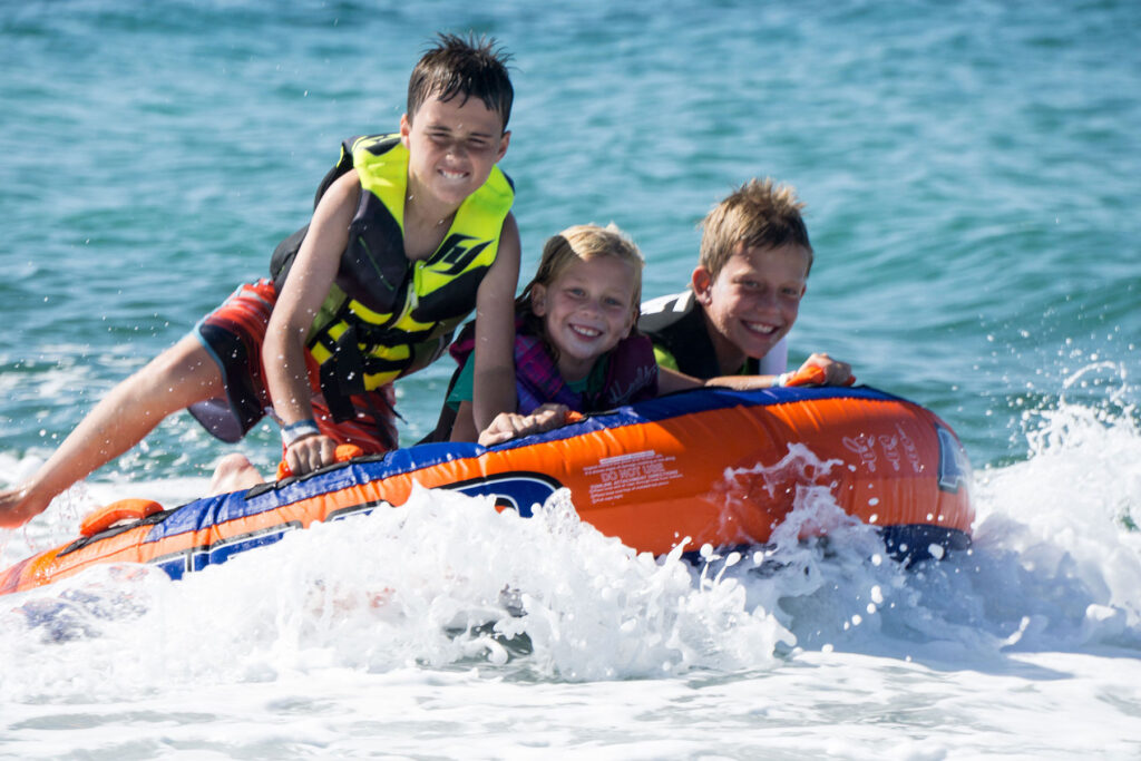 A group of kids play in the surf on a visit to Los Cabos