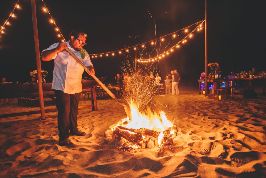 Executive chef Gonzalo Cerda tends a beach bonfire