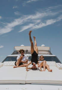 Teens lounge in the sun on the foredeck of a luxury yacht in East Cape Baja Sur
