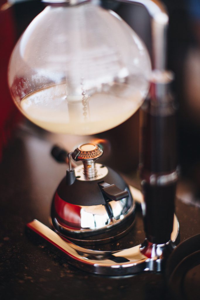 A mixologists beaker is carefully heated over the luxury equivalent of a Bunsen burner